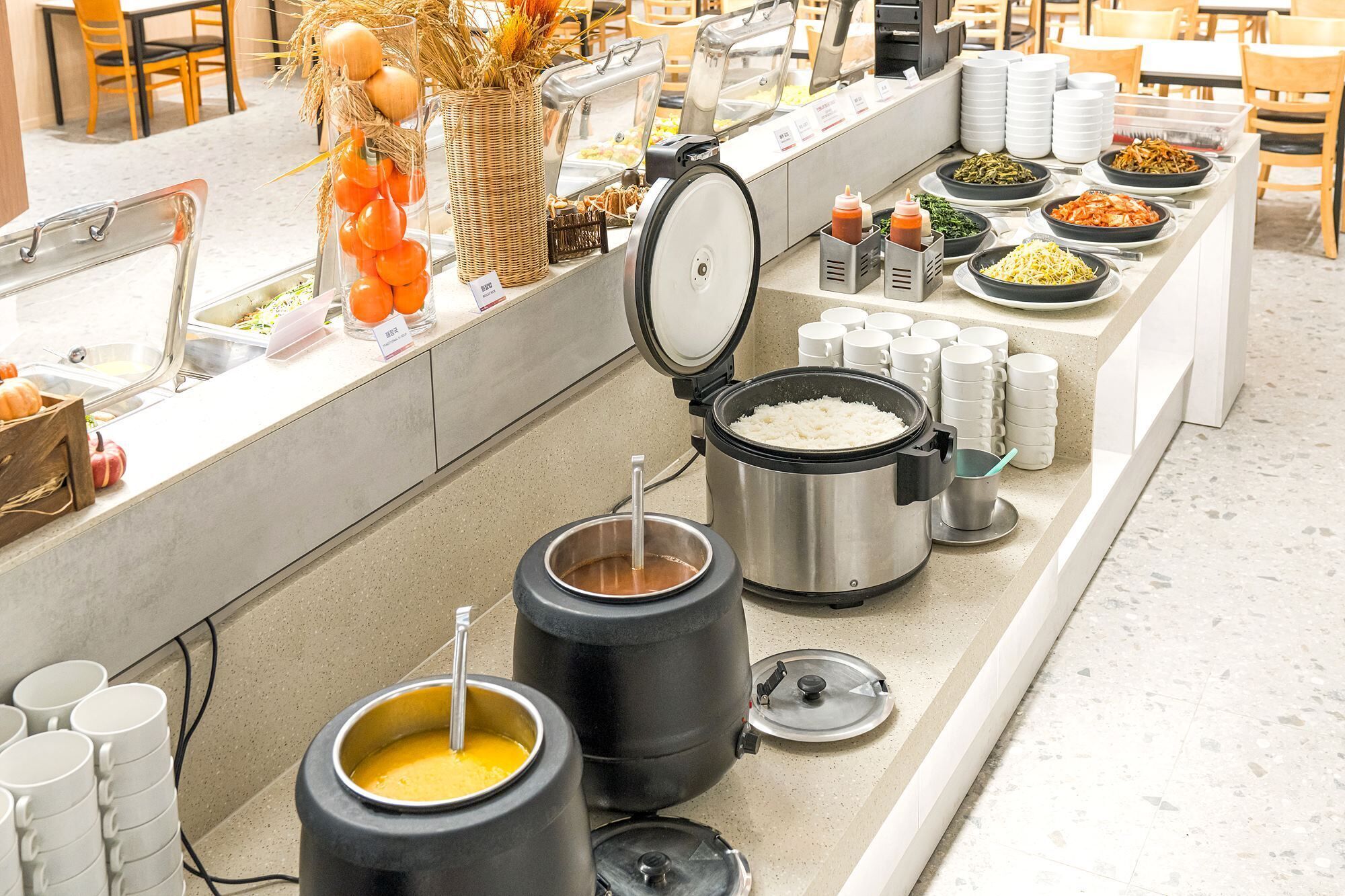 A buffet setup with various food items and condiments.