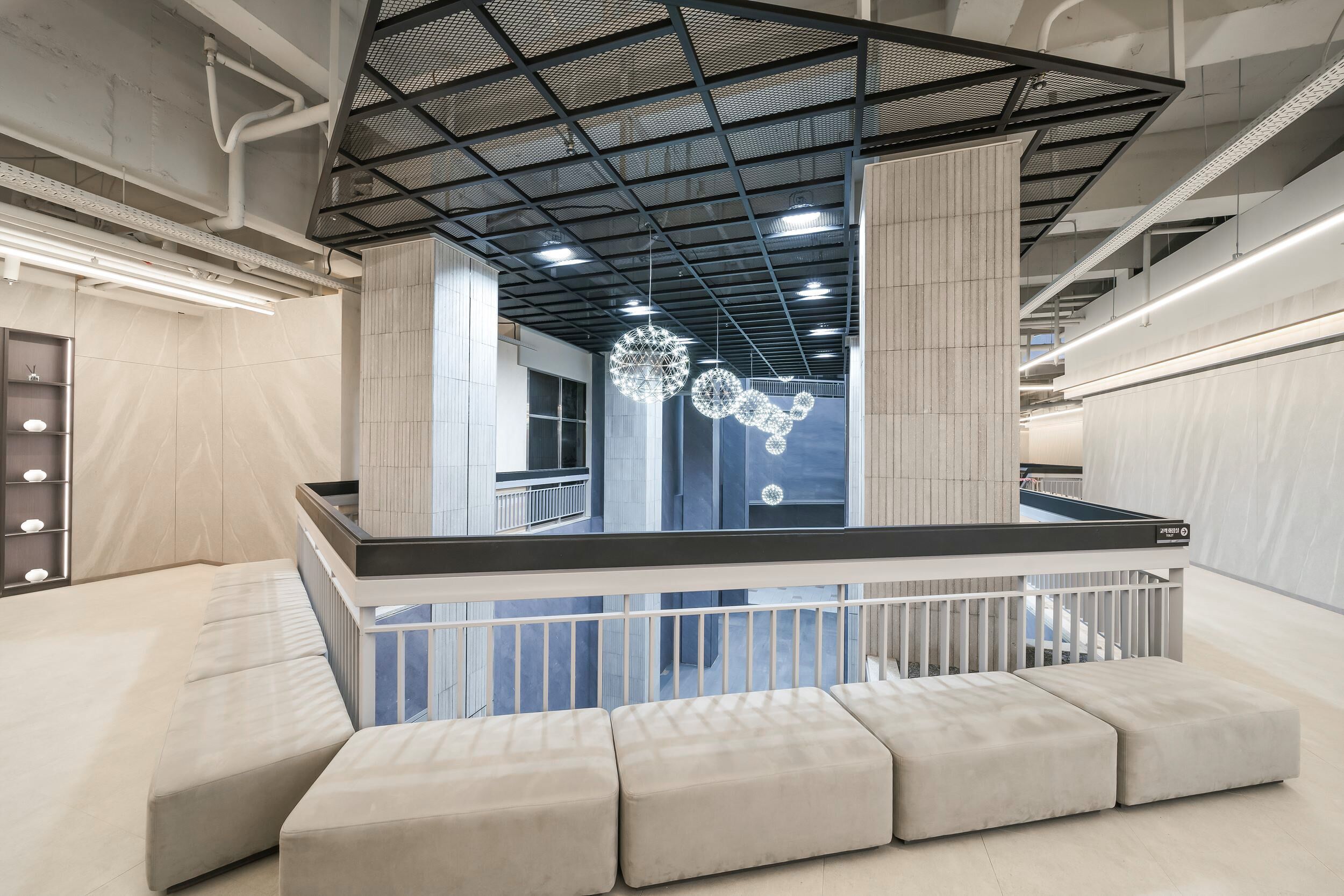 A modern interior with a pool table, cushioned seating, and a decorative light fixture.