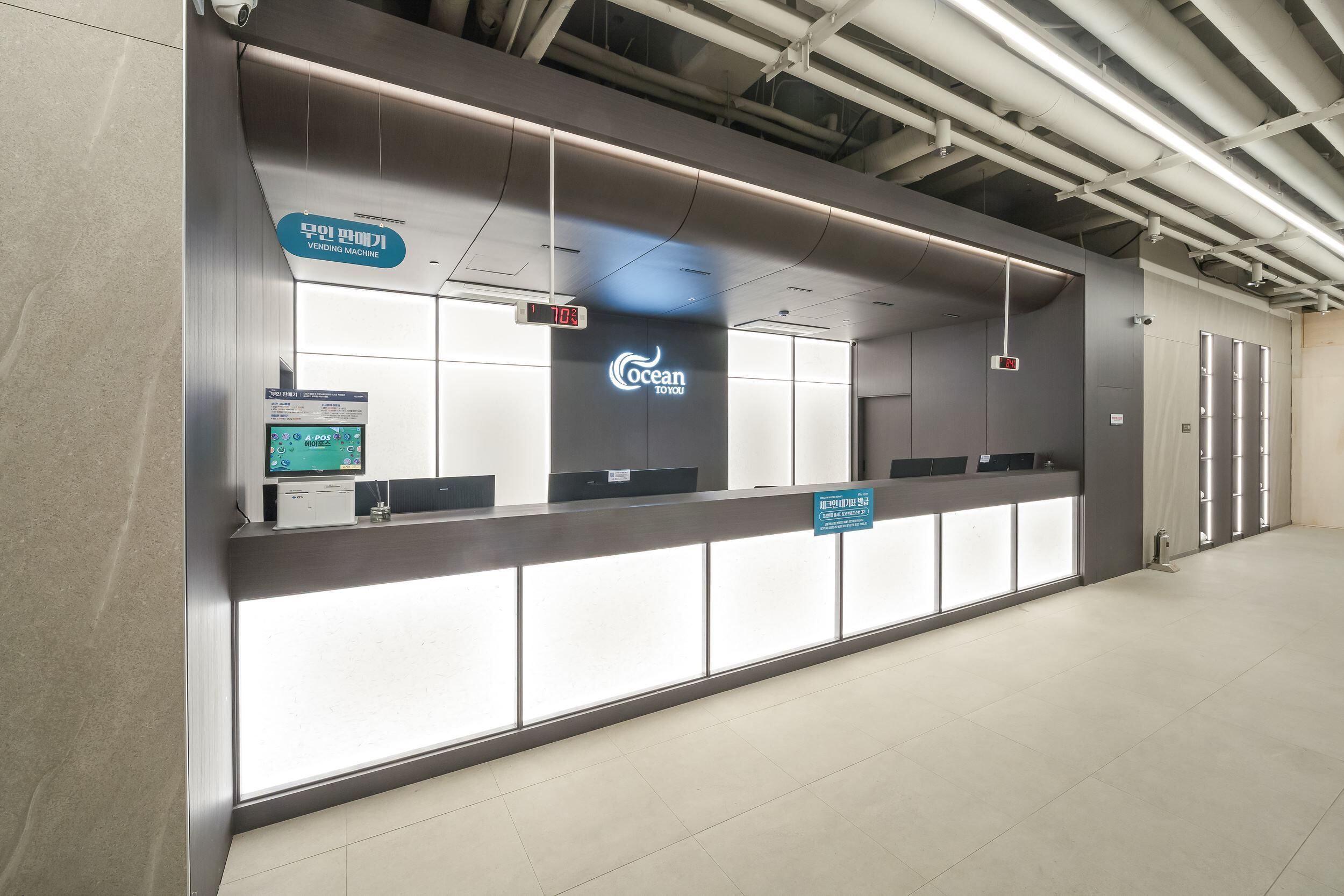 A modern, well-lit vending machine area with digital displays and a clear sign indicating the location.