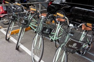 Una fila de bicicletas con cestas identificadas con el rótulo "Grand View Hotel" estacionadas en un área designada.