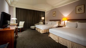 A hotel room with two beds, a desk with a TV, a chair, and a lamp. - Grand View Hotel (Yuanlin)