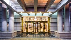 A hotel entrance with a revolving door, large columns, and a glass facade. - Grand View Hotel (Yuanlin)