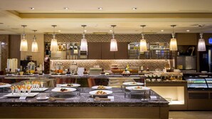 A well-lit hotel restaurant with a marble counter, multiple hanging light fixtures, and a variety of dishes displayed. - Grand View Hotel (Yuanlin)