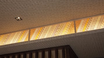 A ceiling with a patterned design and a recessed light fixture.