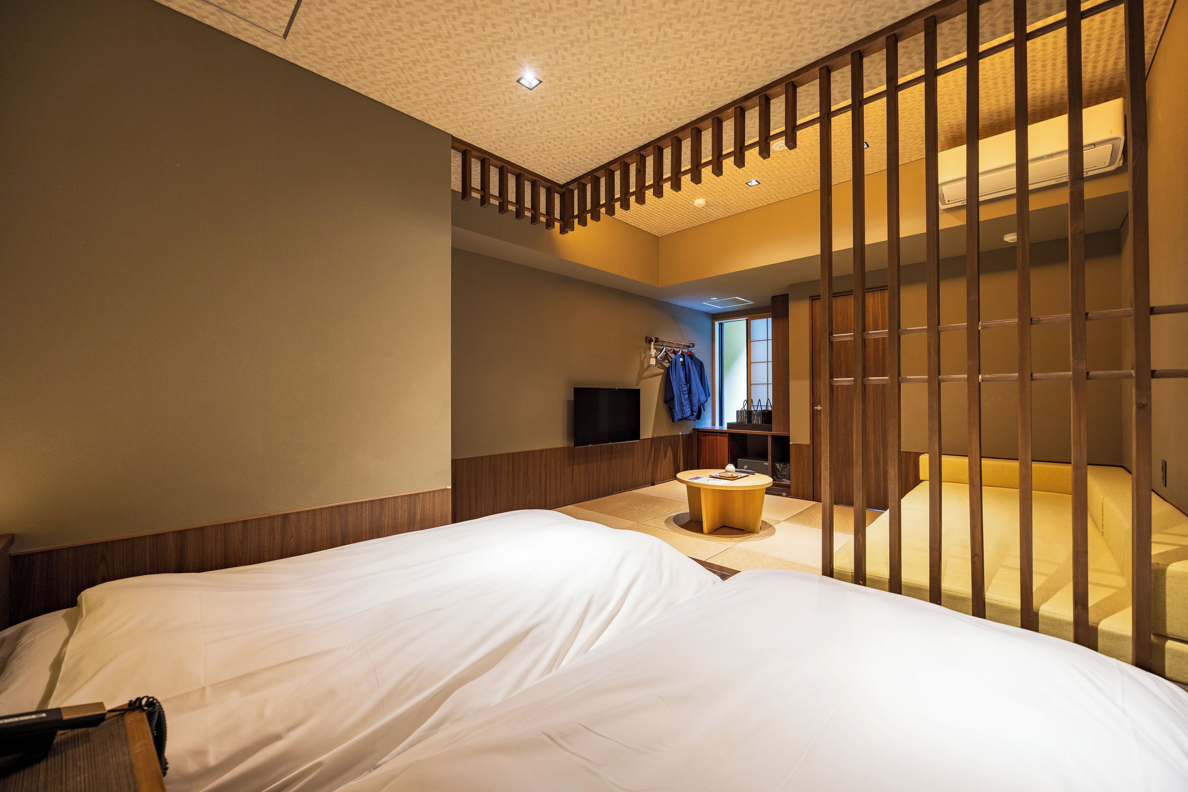 A hotel room with a large bed, a small round table, and a TV.