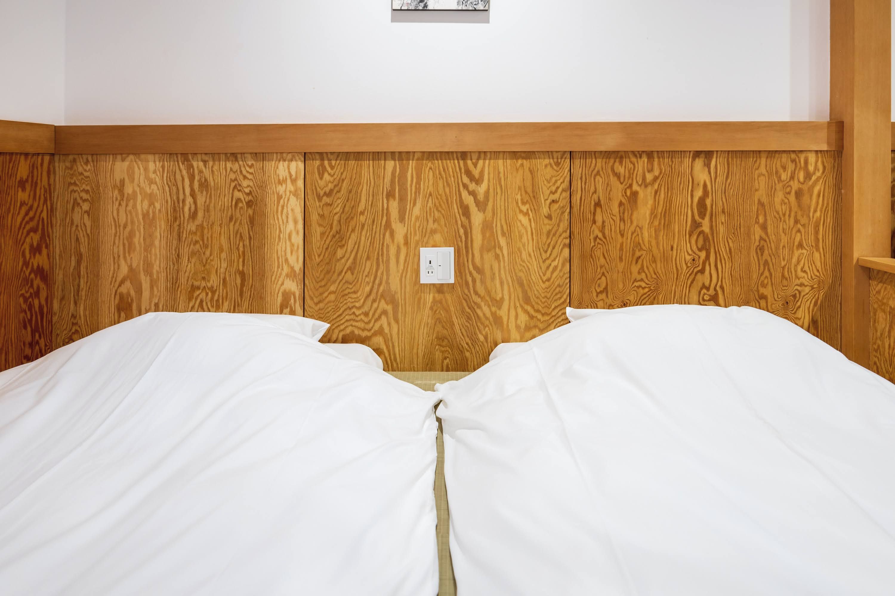 A bed with white bedding and a wooden headboard.