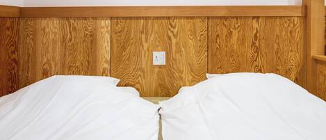 A bed with white bedding and a wooden headboard.