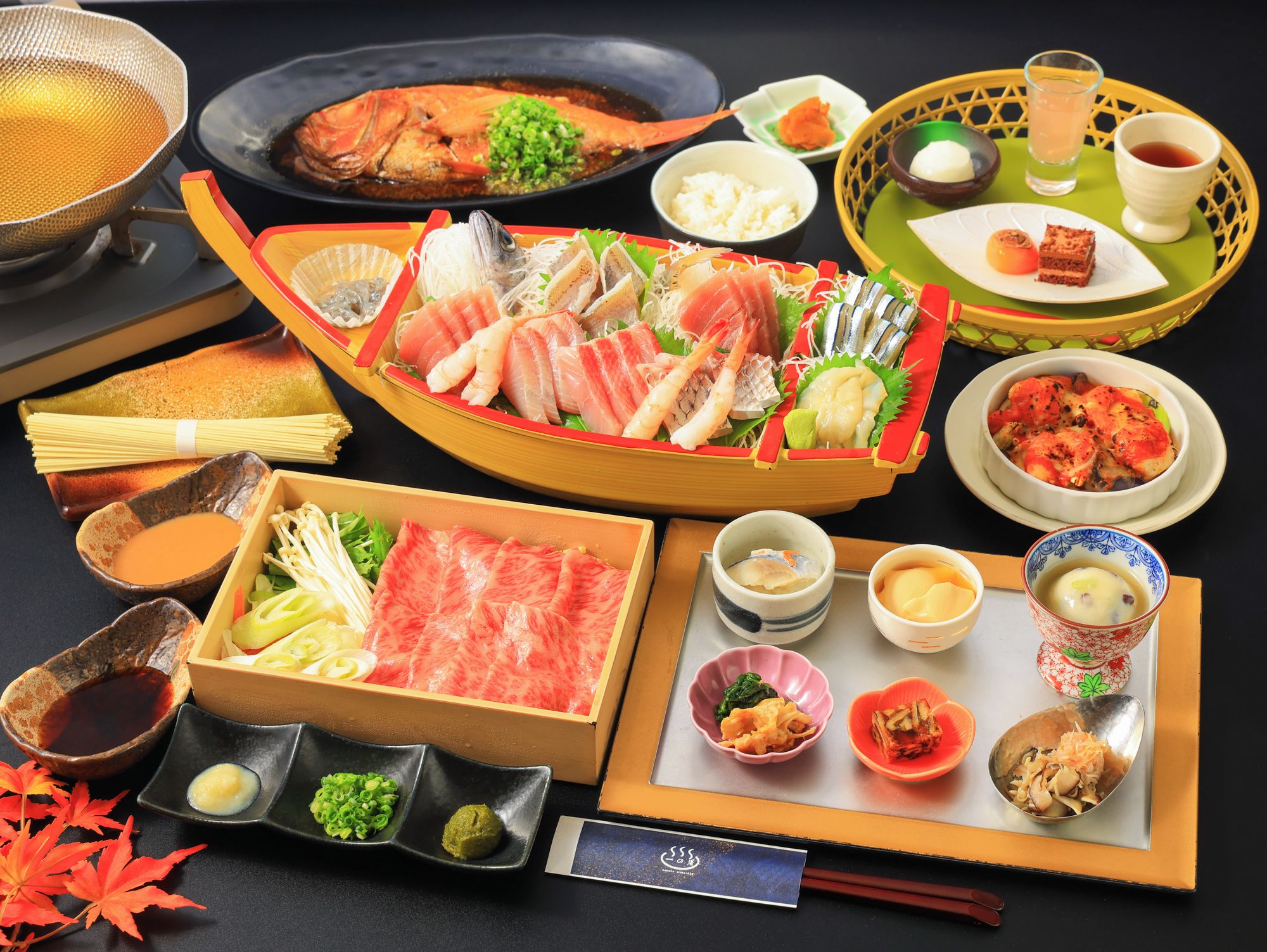 Variedad de platos japoneses, como sashimi, sushi y tempura, presentados sobre una mesa con palillos y pequeños recipientes de condimentos.