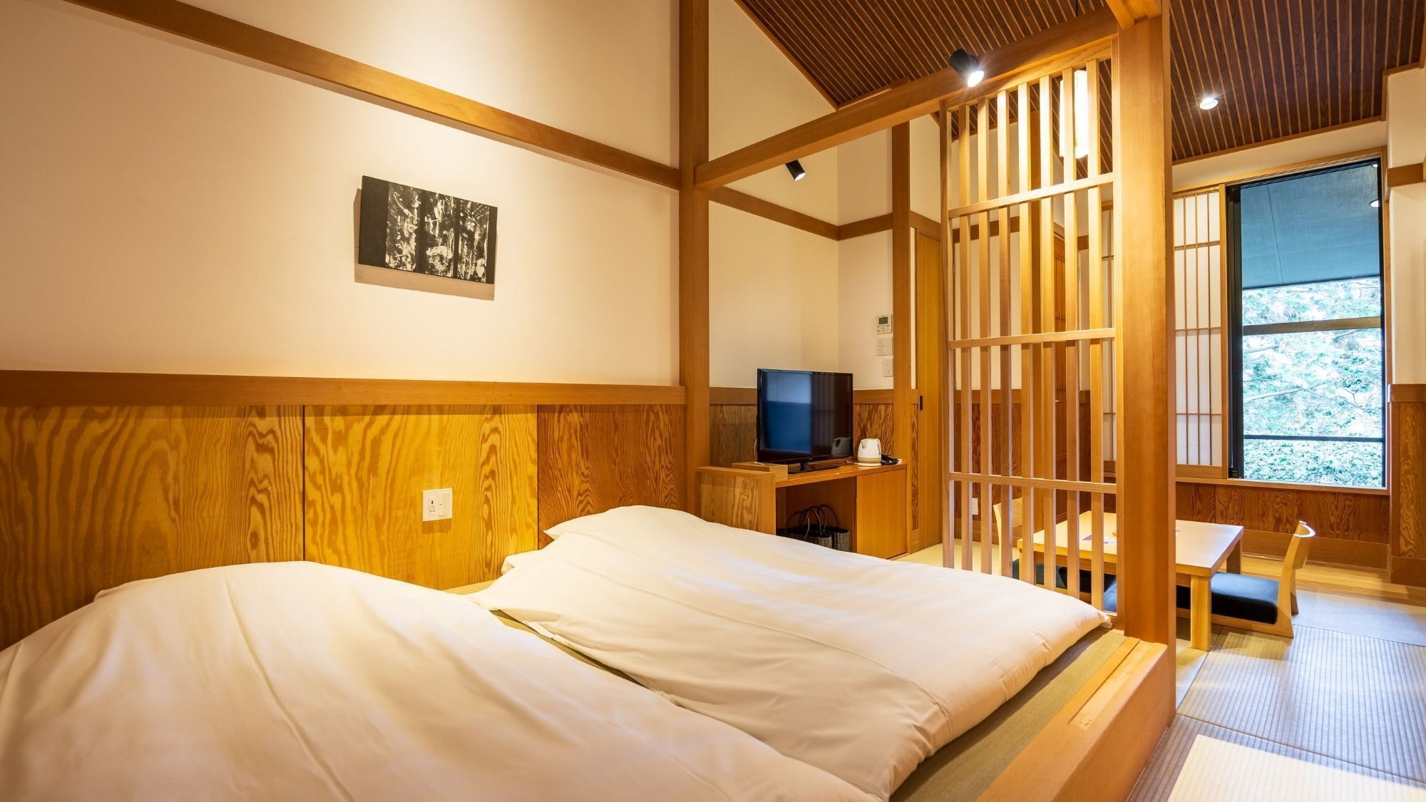 Une chambre avec un lit, une télévision et une vue à travers une cloison en bois.