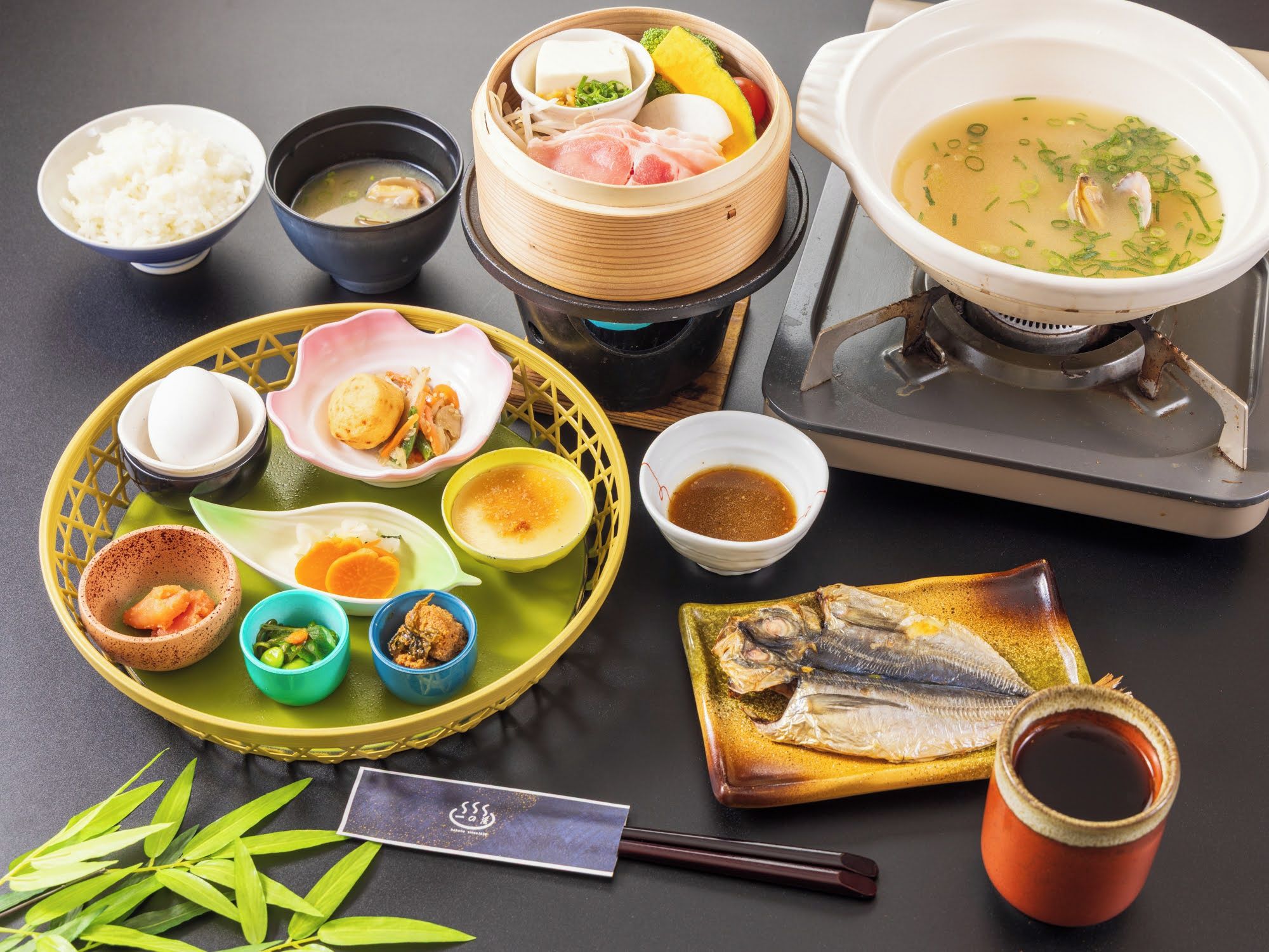 A variety of dishes and food items on a table, including rice, soup, and fish.
