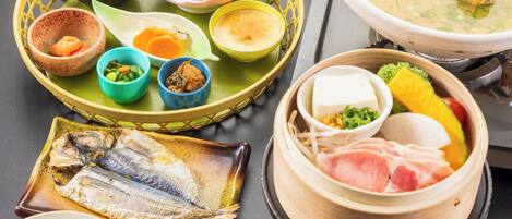 A variety of dishes including fish, rice, and soup, served on a table with a basket and a steamer.
