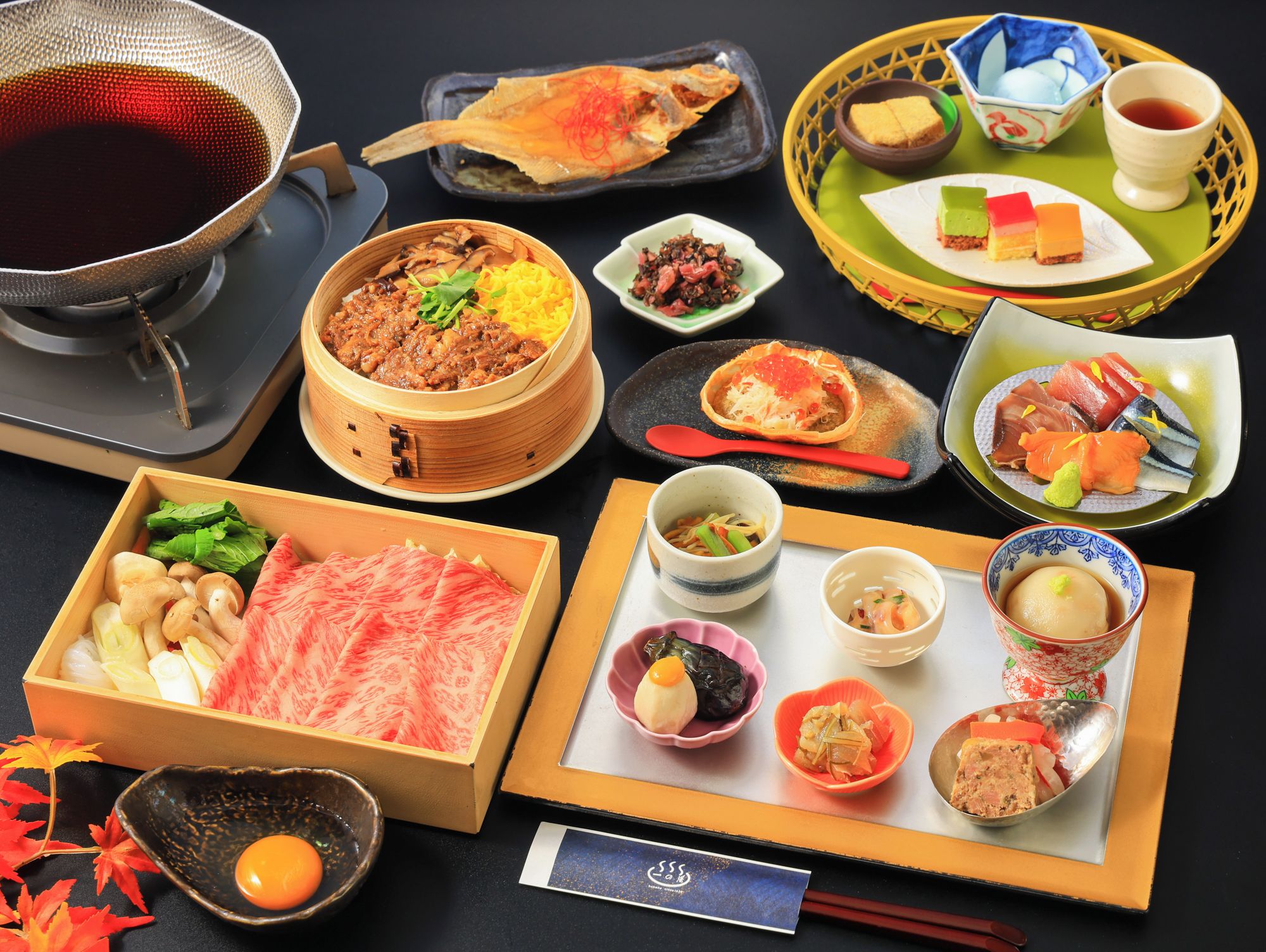 A variety of Japanese dishes including sushi, sashimi, and a hot pot.