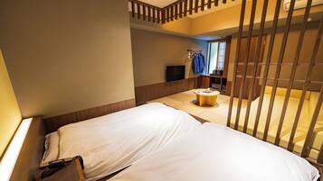 A hotel room with a bed, a small round table, and a TV mounted on the wall.