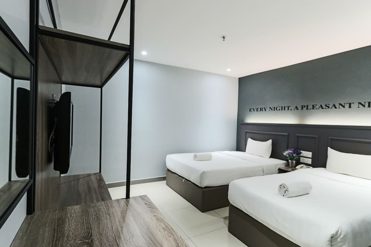Habitación de hotel moderna con dos camas, un armario y un espejo grande.