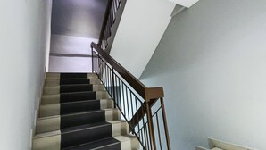Eine Treppe mit schwarz-weißen Stufen und einem Holzgeländer.