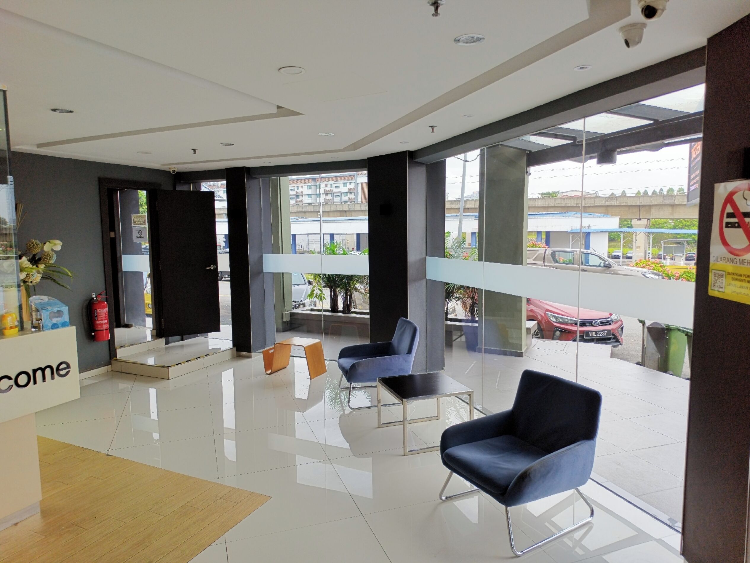 A modern reception area with a glass door entrance, a reception desk, and seating arrangements.