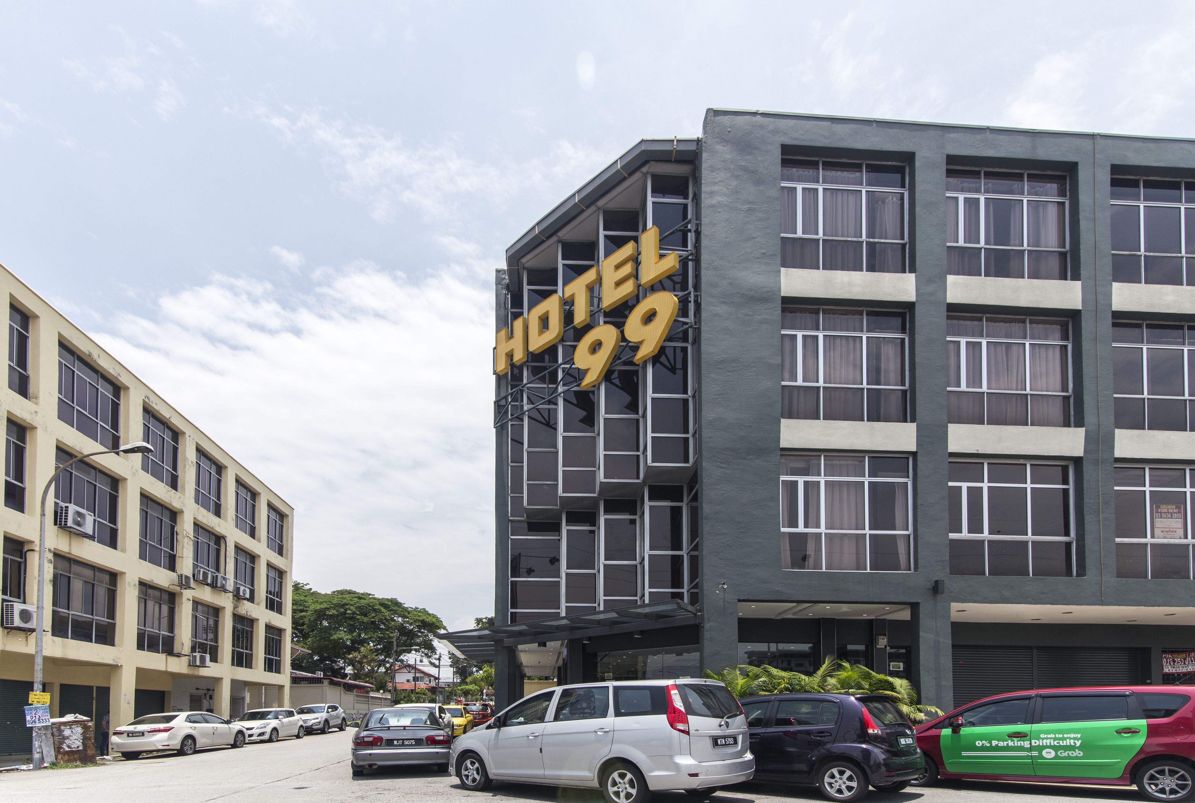 Un edificio de varios pisos con un letrero llamativo que dice "HOTEL 99".