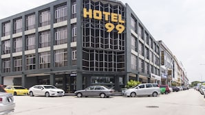 A modern hotel with a prominent 'HOTEL 99' sign, featuring a grid-like facade and multiple windows.
