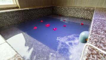 Un baño spa con interior azul, paredes de granito y suelo de mármol.