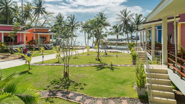 A resort with a pool, palm trees, and a clear sky. - Breeze Bay Villa (Ko Pha-ngan)