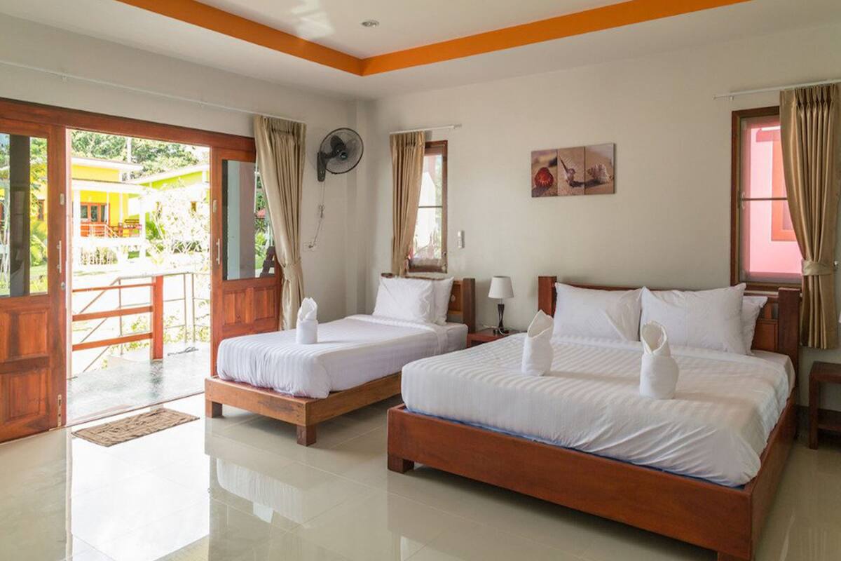 Habitación de hotel con dos camas, un ventilador y vistas al exterior.