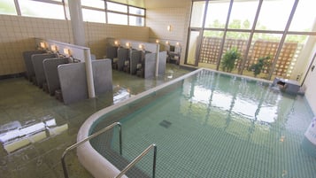 Una piscina interior con paredes y suelo de baldosas, y borde también de baldosas.