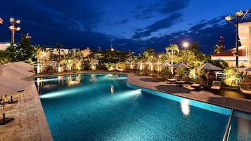 Una piscina al aire libre de temporada, sombrillas