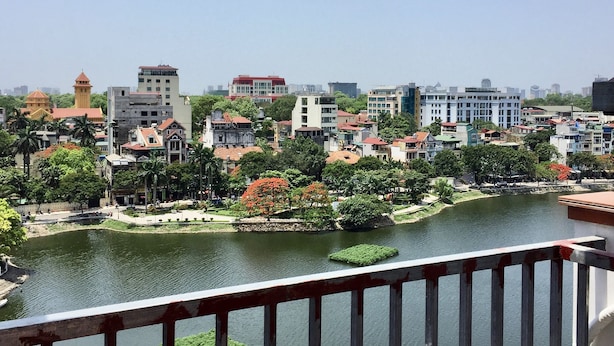 Vista del río con un paisaje urbano, varios edificios, incluyendo una estructura amarilla destacada con una torre.