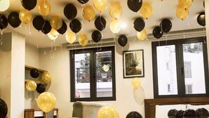 Una habitación con una cama, un sofá y una gran cantidad de globos.