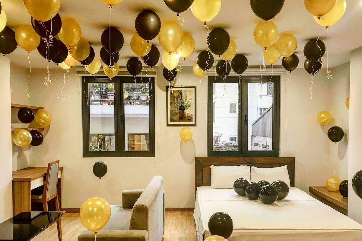 Una habitación de hotel con cama, sofá, escritorio y ventana.