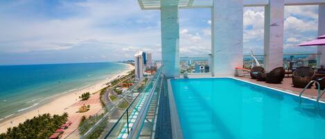 Alberca al aire libre, sombrillas en la alberca y camastros