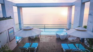 室外游泳池，池畔遮阳伞，日光浴躺椅