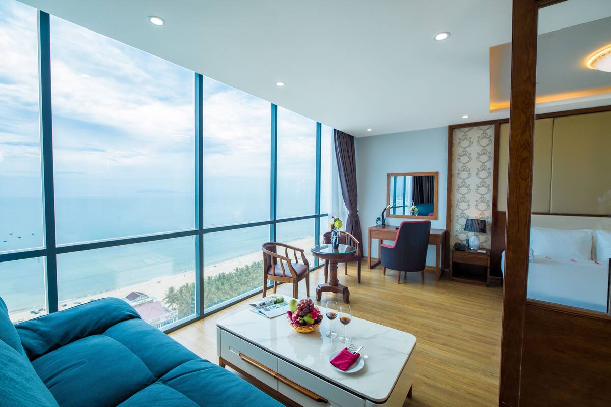 Een moderne hotelkamer met een ruim balkon, een eethoek en een bed.