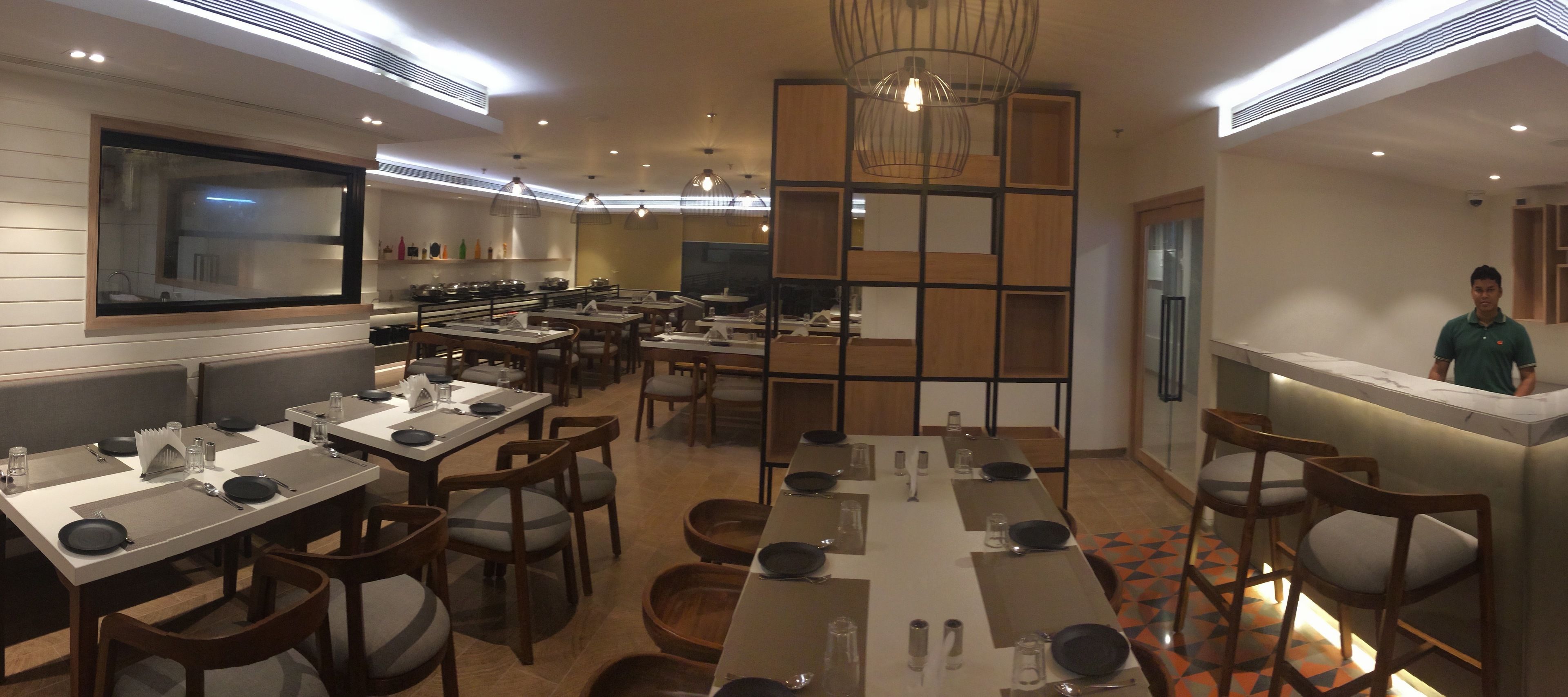 A restaurant with multiple dining tables, chairs, and a bar area.