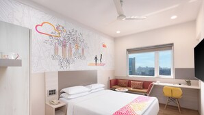 Et moderne hotelværelse med en stor seng, et skrivebord og et vindue med udsigt over byen.