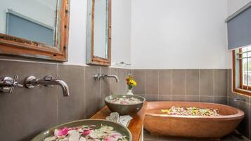 A bathroom with a freestanding bathtub, a large basin sink, and a mirror above the sink.