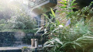 A rustic building with a balcony, surrounded by lush greenery and stone steps. - Tiger Mountain Pokhara Lodge (Pokhara)