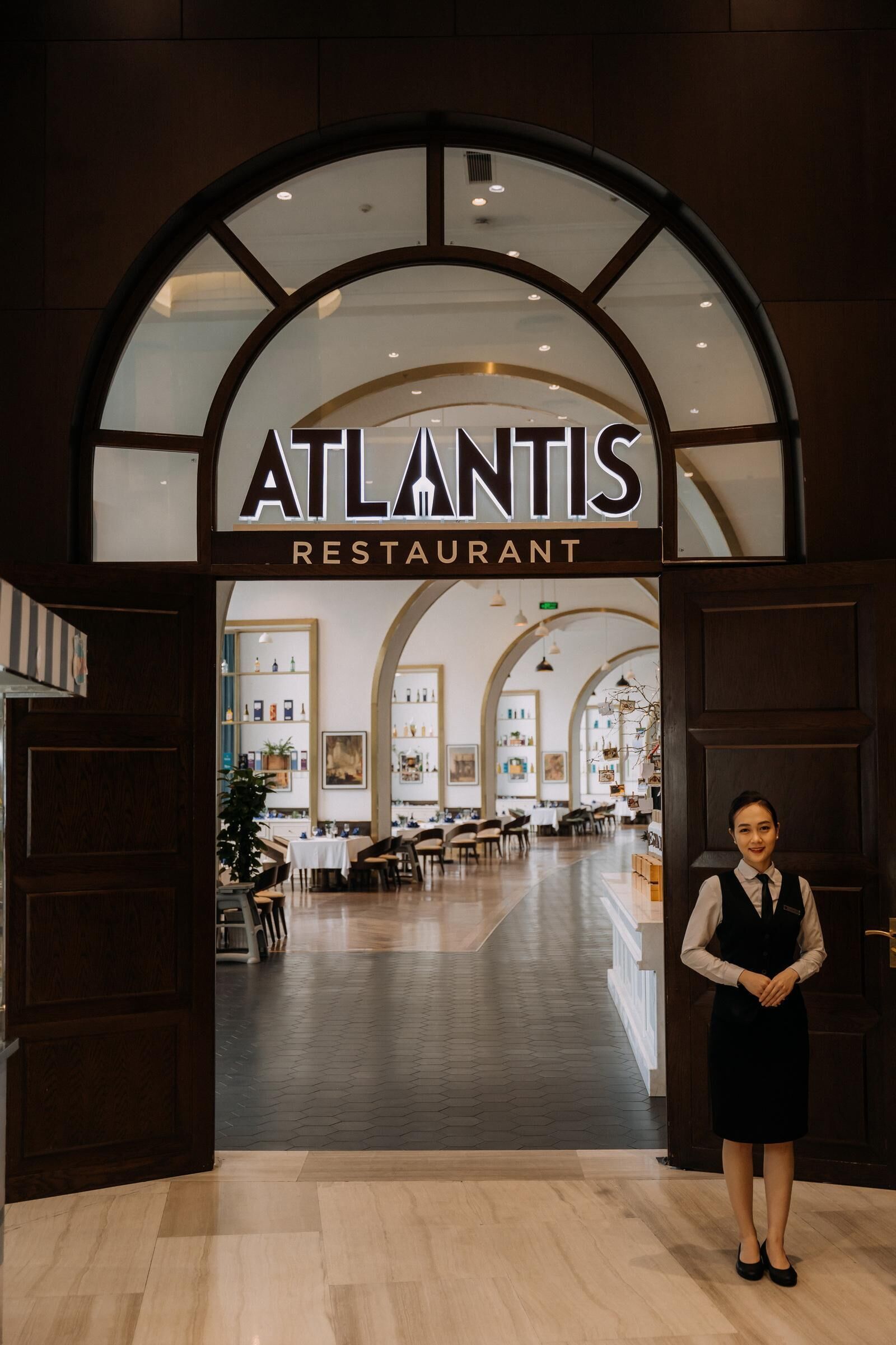 The entrance to the Atlantis Restaurant with a modern interior visible through the glass doors.