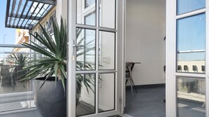 A modern interior with a large potted plant, a table, and a chair. - Semaphore Splash Apartments (Semaphore)