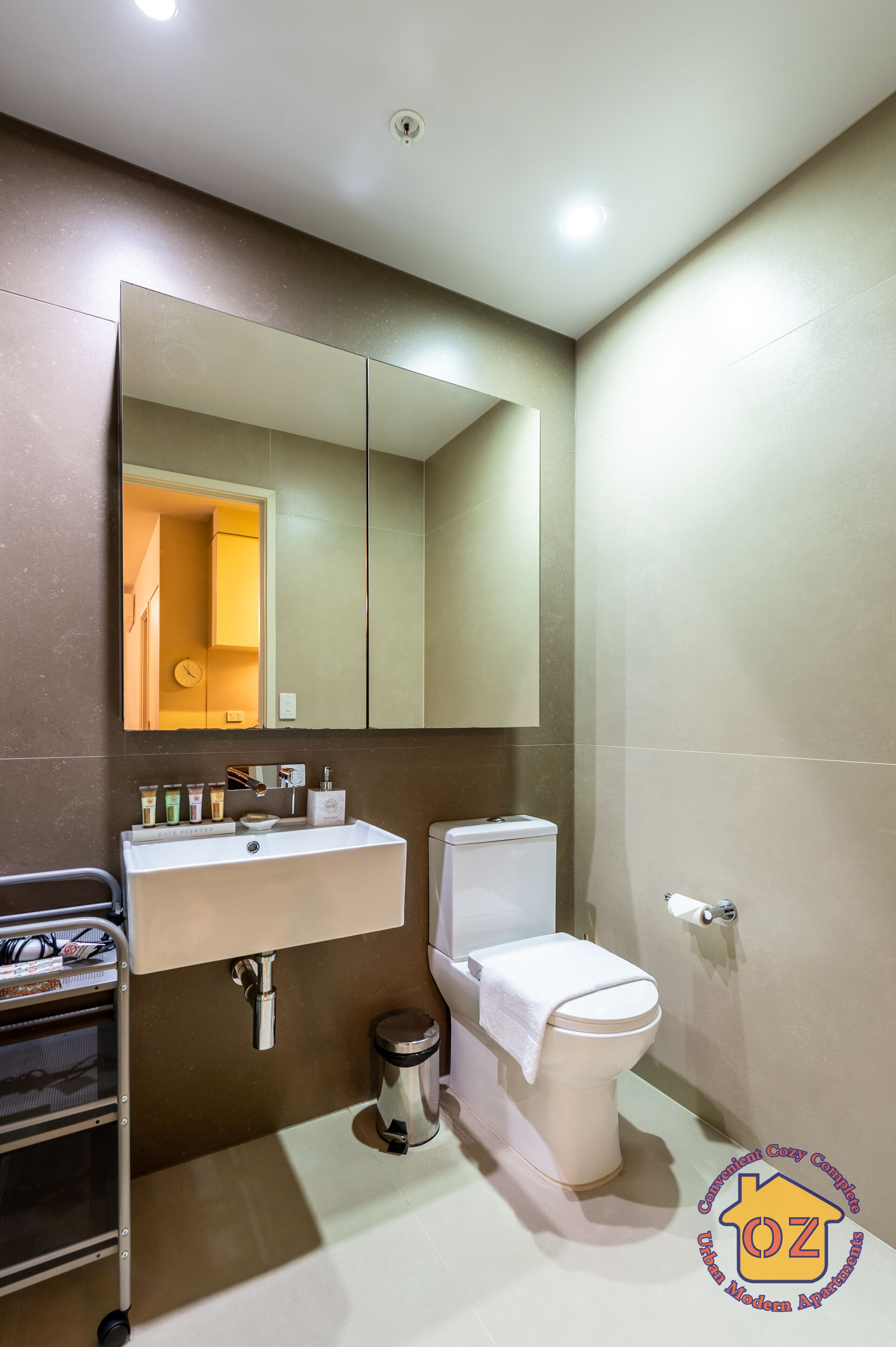 Un baño moderno con inodoro, lavabo y espejo.