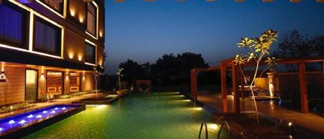 Una piscina al aire libre, sillones reclinables de piscina