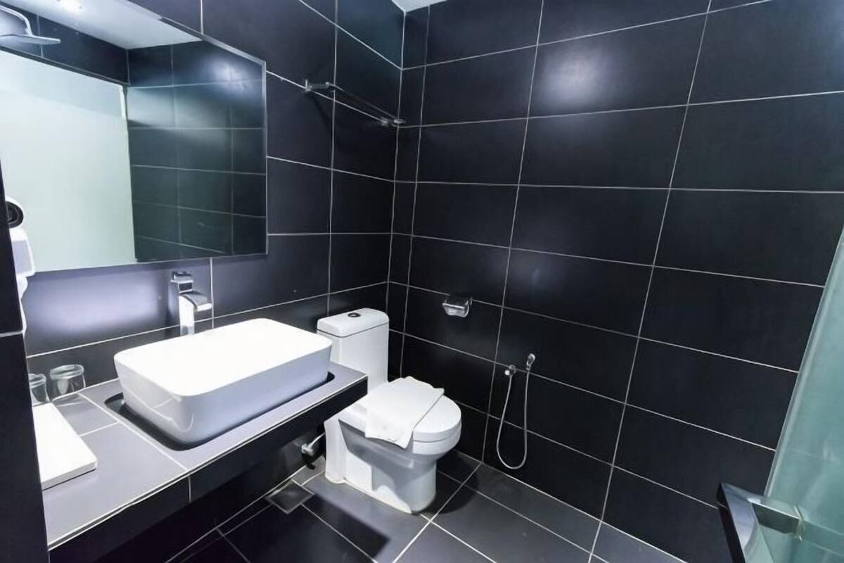 Ein modernes Badezimmer mit weißem Waschbecken, WC und Dusche.