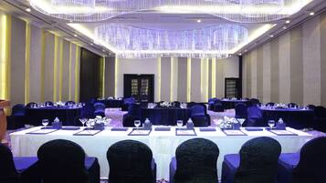 A conference room with multiple tables, chairs, and a podium.