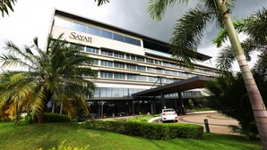 A modern hotel with a glass facade, palm trees, and a covered entrance. - Sayaji Raipur (Raipur)