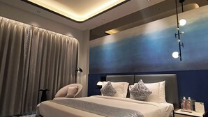 A modern hotel room with a large bed, a nightstand with amenities, and a ceiling with integrated lighting. - Sayaji Raipur (Raipur)