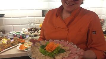 Una persona sostiene un plato con comida en una cocina.
