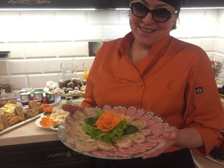 Una persona sostiene un plato con comida en una cocina.