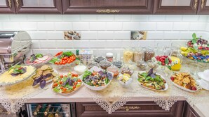A buffet table with various food items and condiments. - Park Lane Hotel (Chisinau)