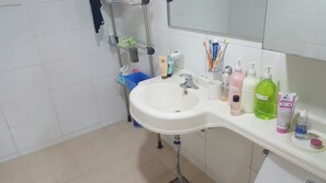 A bathroom with a sink, mirror, and various toiletries.