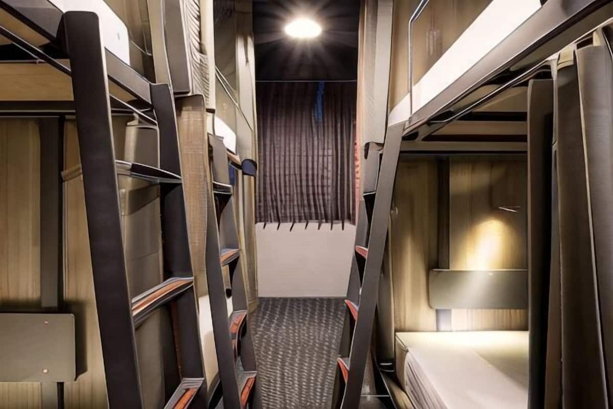 A narrow corridor with bunk beds, a patterned floor, and a curtain at the end.